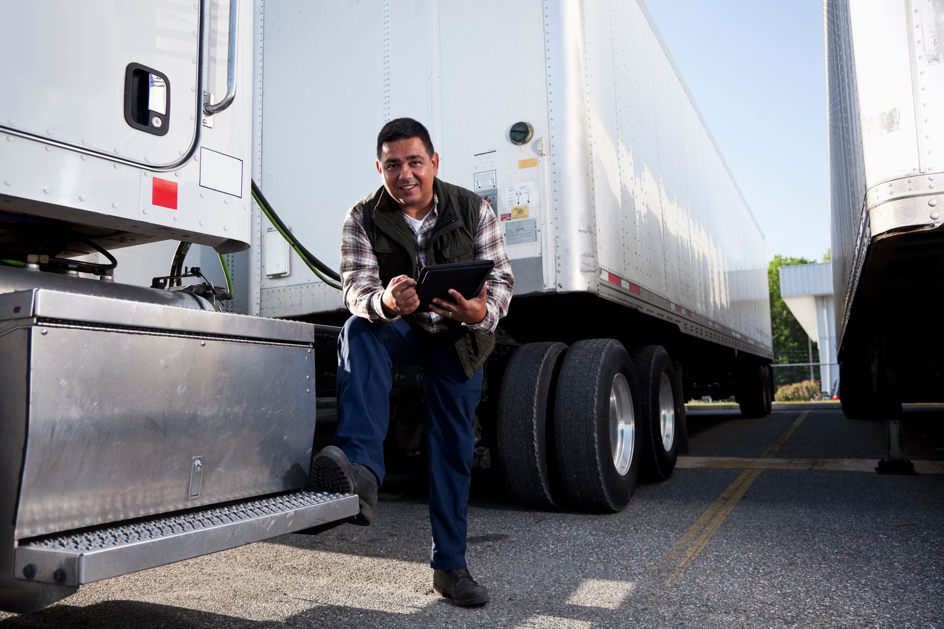 Hispanic truck driver with digital tablet